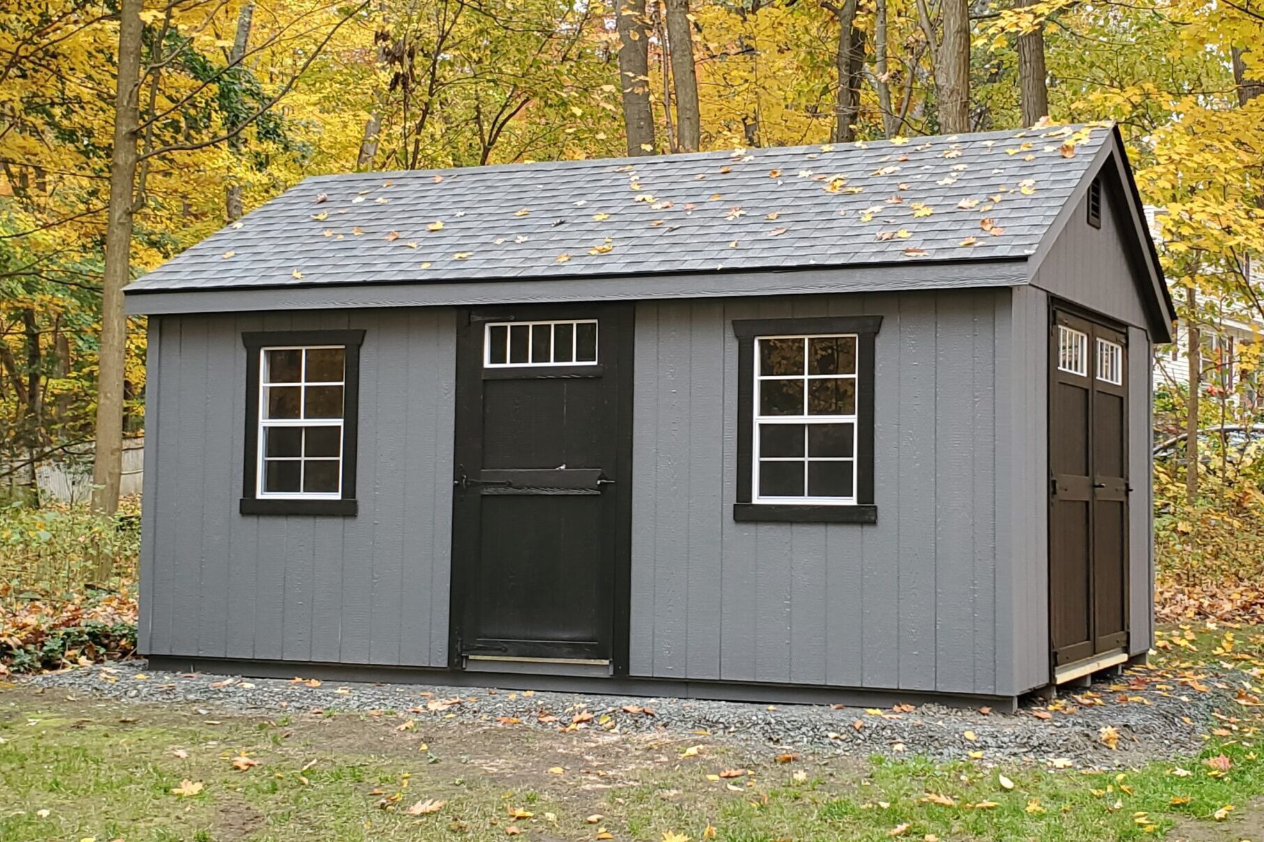 A simple gray A-frame wooden garden shed