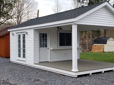 A large pool-house-style cabin structure in the backyard sheds a lot