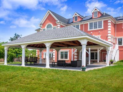 A pavilion in front of a large red brick house