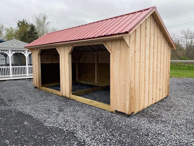 A wooden animal shelter structure with barn-shaped doors