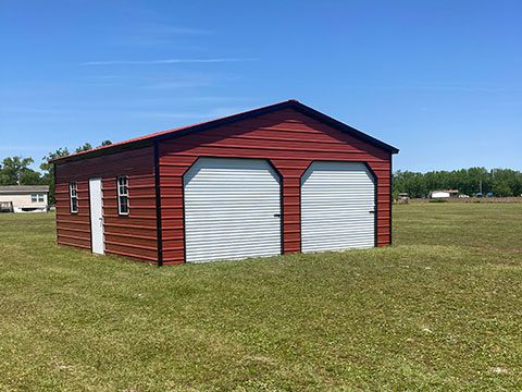 A large red metal building built onto a farm field