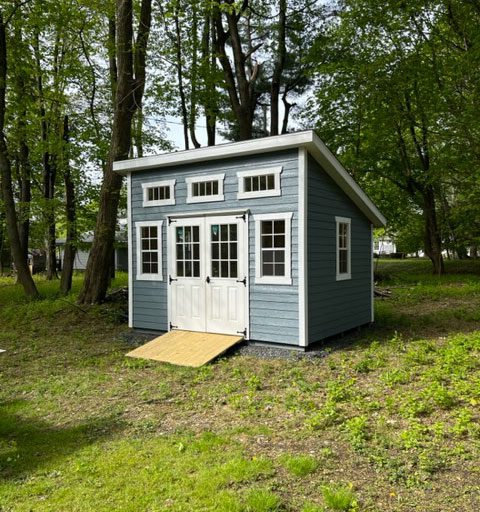 An asymmetric A-Frame with the double-doors off to one side and smartside lap siding all over.