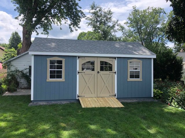 A blue New England cottage shed.